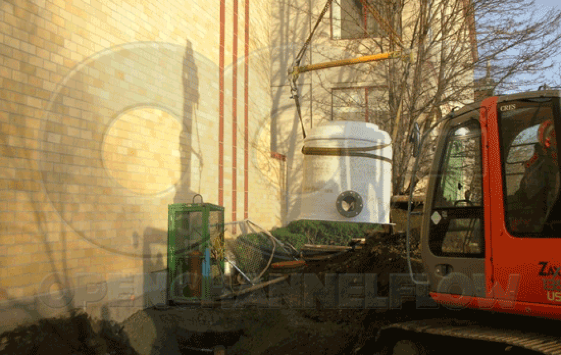 lowering a fiberglass Metering Manhole into excavation