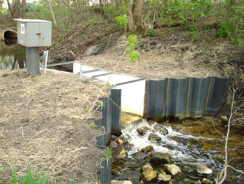 corrugated metal walls to divert flow into a Parshall flume