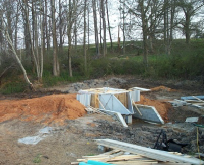 H flume being embedded during installation in a earthen swale