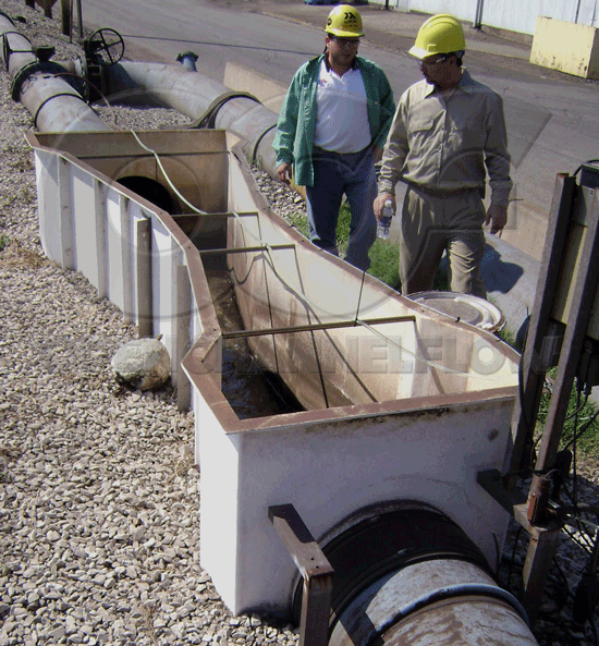 above ground fiberglass (FRP) parshall flume with end adapters connecting to piping to monitor industrial discharge