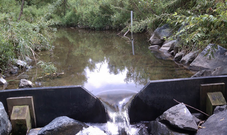 v-notch weir measuring water in a natural channel