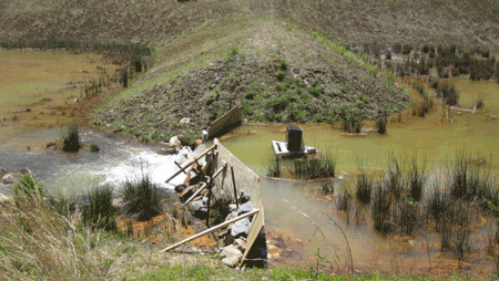 Wooden wing walls directing a large drainage flow to a Weir