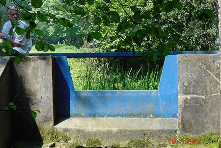 Cipolletti weir plate measuring flow in a natural channel