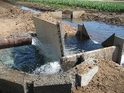 underflow baffle conditioning pipe flow prior to a weir
