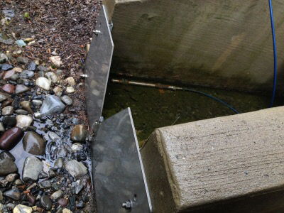 v-notch weir plate at the end of a concrete channel measuring runoff